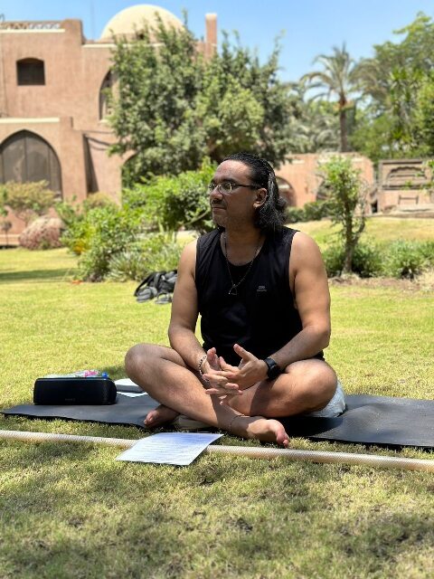 Karim Strougo teaching a yoga group outdoors